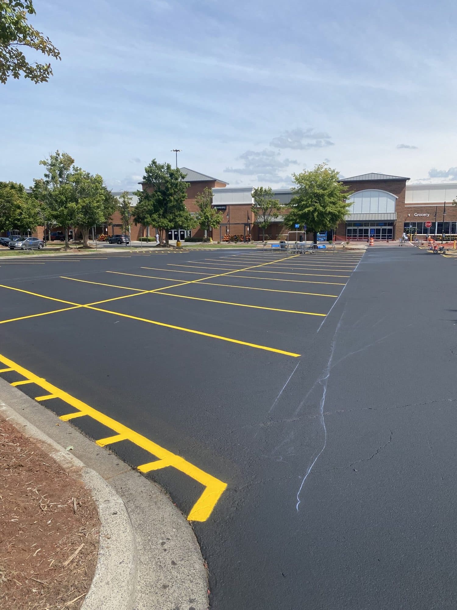Yellow curb and stall markings on a newly surfaced lot