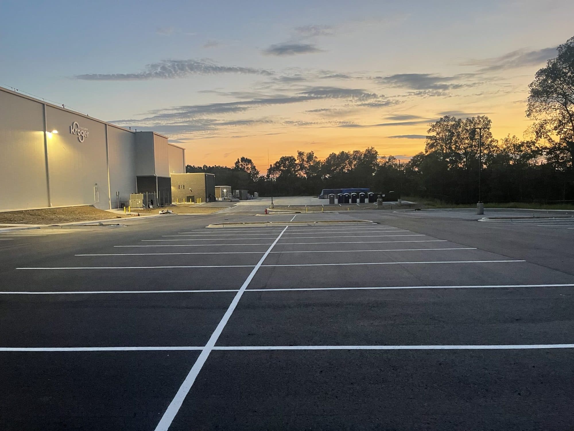 New parking lot and drive lane at dusk after paving and striping
