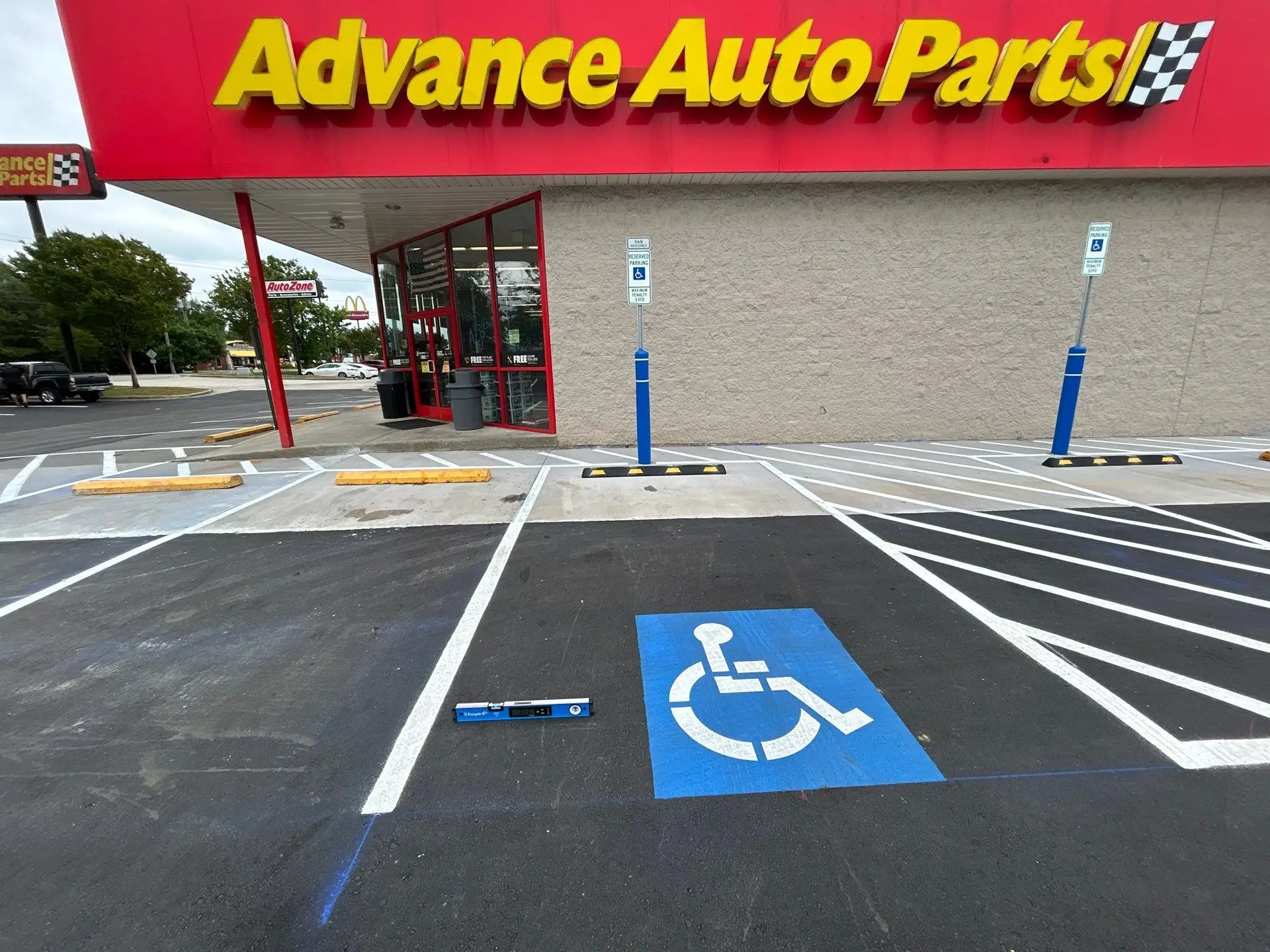 Crown Paving measuring the slope of an ADA access ramp