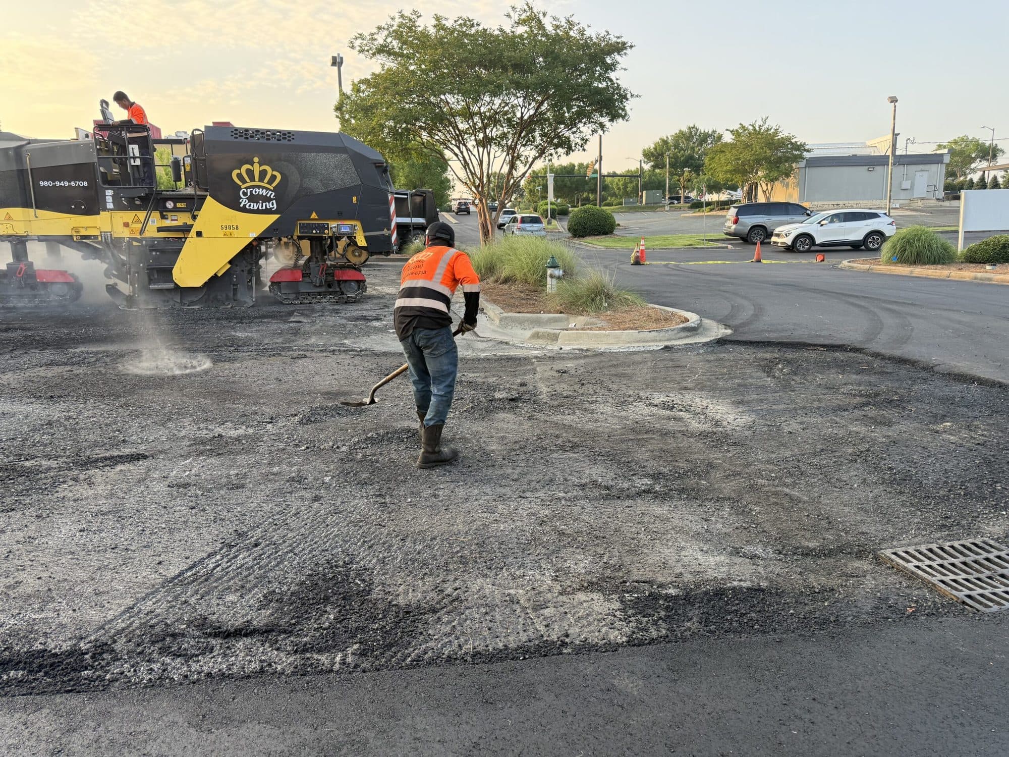 Milling drum lifting the worn surface layer off a commercial lot